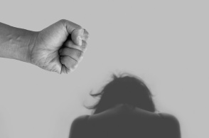 Γυναίκα προστατεύει με τα χέρια της το πρόσωπό της από τον κακοποιητή της