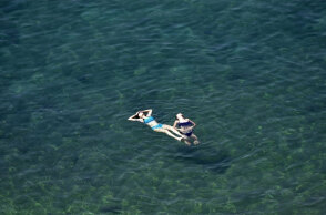 Λουόμενες στην παραλία απολαμβάνουν τη θάλασσα