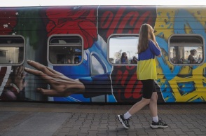 Κοπέλα με την ουκρανική σημαία περνά μπροστά από τρένο στο Κίεβο