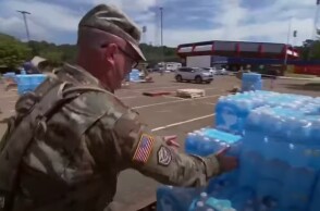 Στρατιώτης μεταφέρει μπουκάλια με νερό στο Τζάκσον