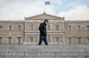 Άνδρας με μπουφάν και μάσκα μπροστά από τη Βουλή