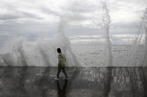 Παιδί παίζει με τα κύματα στο Παλαιό Φάληρο, καθώς η κακοκαιρία EVA επηρεάζει την Αττική