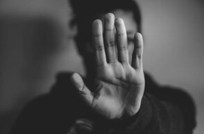 Γυναίκα κρύβει με το χέρι της το πρόσωπό της