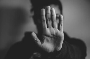 Γυναίκα προτάσσει το χέρι της κρύβοντας το πρόσωπό της