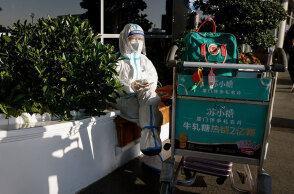 Γυναίκα με προστατευτική στολή στο Διεθνές Αεροδρόμιο του Ξιάμεν (επαρχία Φουτσιάν)