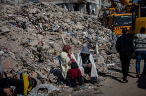 Κάτοικοι στην πόλη Χατάι της Τουρκίας κάθονται δίπλα από έναν σωρό με ερείπια μετά τον σεισμό