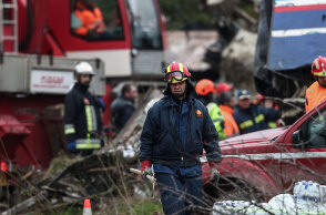 Πυροσβέστης στα Τέμπη με φόντο τα συντρίμμια μετά τη σύγκρουση τρένων