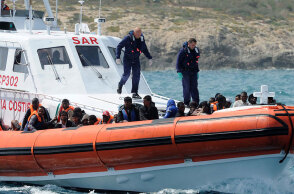 Σκάφος της ιταλικής Ακτοφυλακής μπροστά σε φουσκωτό με μετανάστες από την Αφρική