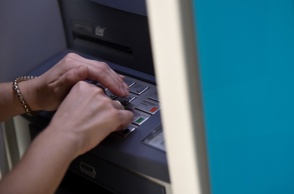 Άτομο μπροστά σε ΑΤΜ πληκτρολογεί τον κωδικό της κάρτας του