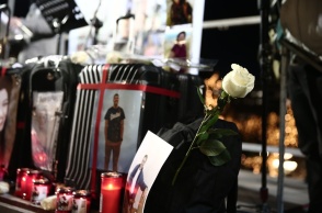 Κεριά, λευκά τριαντάφυλλα, λουλούδια και φωτογραφίες σε βαλίτσα στη μνήμη των θυμάτων της πολύνεκρης τραγωδίας στα Τέμπη