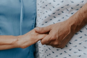 Δύο γυναίκες μεγάλης ηλικίας κρατάνε η μία το χέρι της άλλης φορώντας μπλε και άσπρο φόρεμα αντίστοιχα χωρίς να φαίνονται πρόσωπα