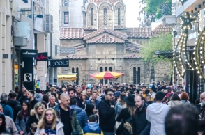 Πλήθος κόσμου περπατάει στην Ερμού μπροστά από μαγαζιά - Στο βάθος η εκκλησία Καπνικαρέα