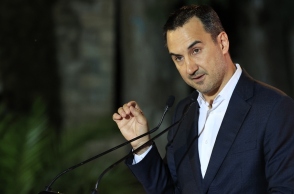 Ο Αλέξης Χαρίτσης μιλάει όρθιος μπροστά σε μικρόφωνο