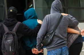 4 άνδρες με κουκούλες μπαίνουν σε όχημα αστυνομίας