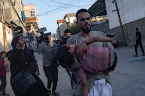 ανδρας κραταει τραυματισμένο παιδι