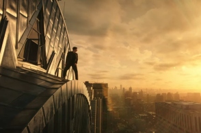 ανδρας πανω σε πολυκατοικια, ουρανος, συννεφα