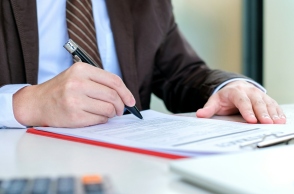 ανδρας συμπληρωνει αιτηση, στυλος