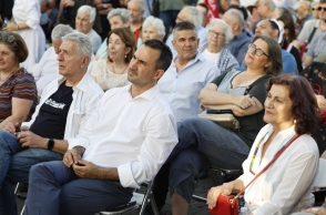 ο Αλέξη Χαρίτση καθισμενος αναμεσα σε κοσμο