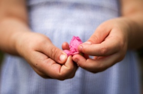 Τα χεράκια παιδιού που κρατά λουλουδάκι