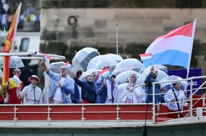 γαλλοι αθλητες σε βαρκα με αδιαβροχα, σημαιες και ομπρελες