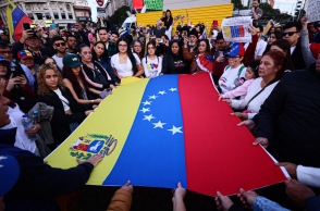 Διαδηλωτες κρατουν τη σημαια της Βενεζουελας