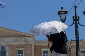 αθηναιος με ομπρελα μπροστα στη Βουλη, ελληνικη σημαια
