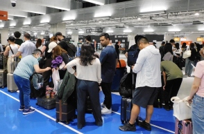 επιβατες περιμενουν στον ελεγχο αποσκευων αεροδρομιου