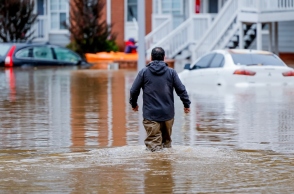 ανδρας περπαταει σε πλημμυρισμενη πολη