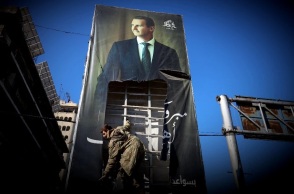 Τζιχαντιστής σκίζει αφίσα του Σύριου πρόεδρου, Μπασάρ αλ Άσαντ στο Χαλέπι