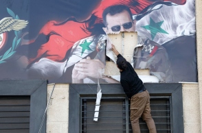Κάτοικος της Συρίας σχίζει αφίσα του Άσαντ στη Δαμασκό