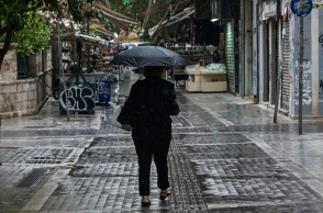 Άτομο με ομπρέλα περπατά εν μέσω βροχής