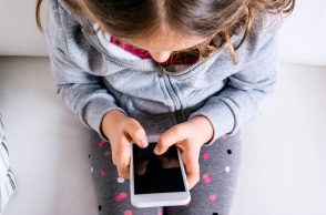 παιδι καθισμενο κραταει κινητο