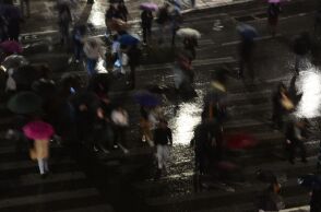 Άνθρωποι περπατούν σε δρόμο κατά την διάρκεια βροχόπτωσης