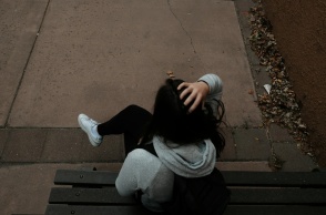 Ανήλικη καθισμένη σε παγκάκι με την πλάτη γυρισμένη στον φακό