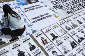 Ένα άτομο κοιτάζει εικόνες πολιτικών κρατουμένων κατά τη διάρκεια διαμαρτυρίας στην Plaza del Rectorado UCV στο Καράκας, Βενεζουέλα