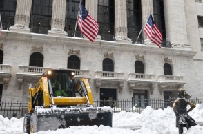 Εργάτες καθαρίζουν το χιόνι μπροστά στο γλυπτό «Το Ατρόμητο Κορίτσι» έξω από το Χρηματιστήριο της Νέας Υόρκης 