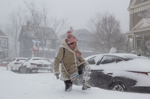 Γυναίκα περπατά με δυσκολία στους χιονισμένους δρόμους στο Μπάφαλο