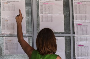 Αποτελέσματα Πανελληνίων 2022: Γυναίκα κοιτά τις βαθμολογίες έξω από σχολείο 