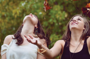 Κορίτσια παίζουν με πεσμένα φύλλα