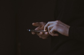 Χέρια πληκτρολογούν σε τηλέφωνο