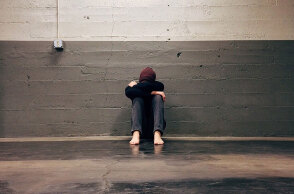 Παιδί με τα χέρια στα πόδια του κάθεται σε διάδρομο 