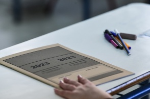 Τετράδιο εξετάσεων και παραταγμένα στιλό σε θρανίο για τις Πανελλήνιες 2023