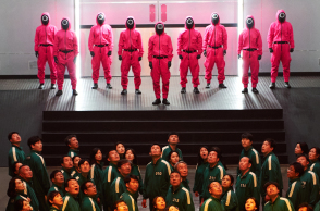 Άνθρωποι με κόκκινες και πράσινες στολές - Σκηνή από τη σειρά Squid Game