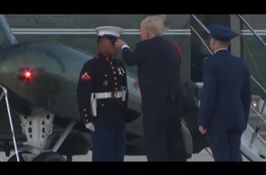 Trump struggles to retrieve marine hat blown off by the wind