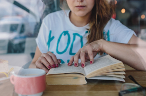 kaboompics_woman_reading_book_at_coffee_shop.jpg