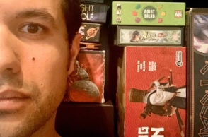 Ο Ορφέας Αυγουστίδης μπροστά από τα επιτραπέζια που μας προτείνει για όσο Μένουμε Σπίτι