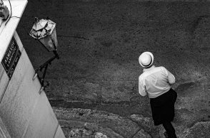 Φωτογραφία με έναν άνθρωπο με καπέλο στον άδειο δρόμο του Συντάγματος