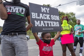 Ένα μικρό παιδί στις ΗΠΑ κρατάει πανό κατά του ρατσισμού