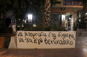 Συνθήματα στις ζαρντινιέρες με τους φοίνικες στην οδό Πανεπιστημίου κατά μήκος του «Μεγάλου Περιπάτου της Αθήνας»