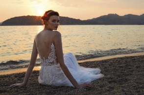 Κοπέλα με νυφικό καθισμένη στην άμμο